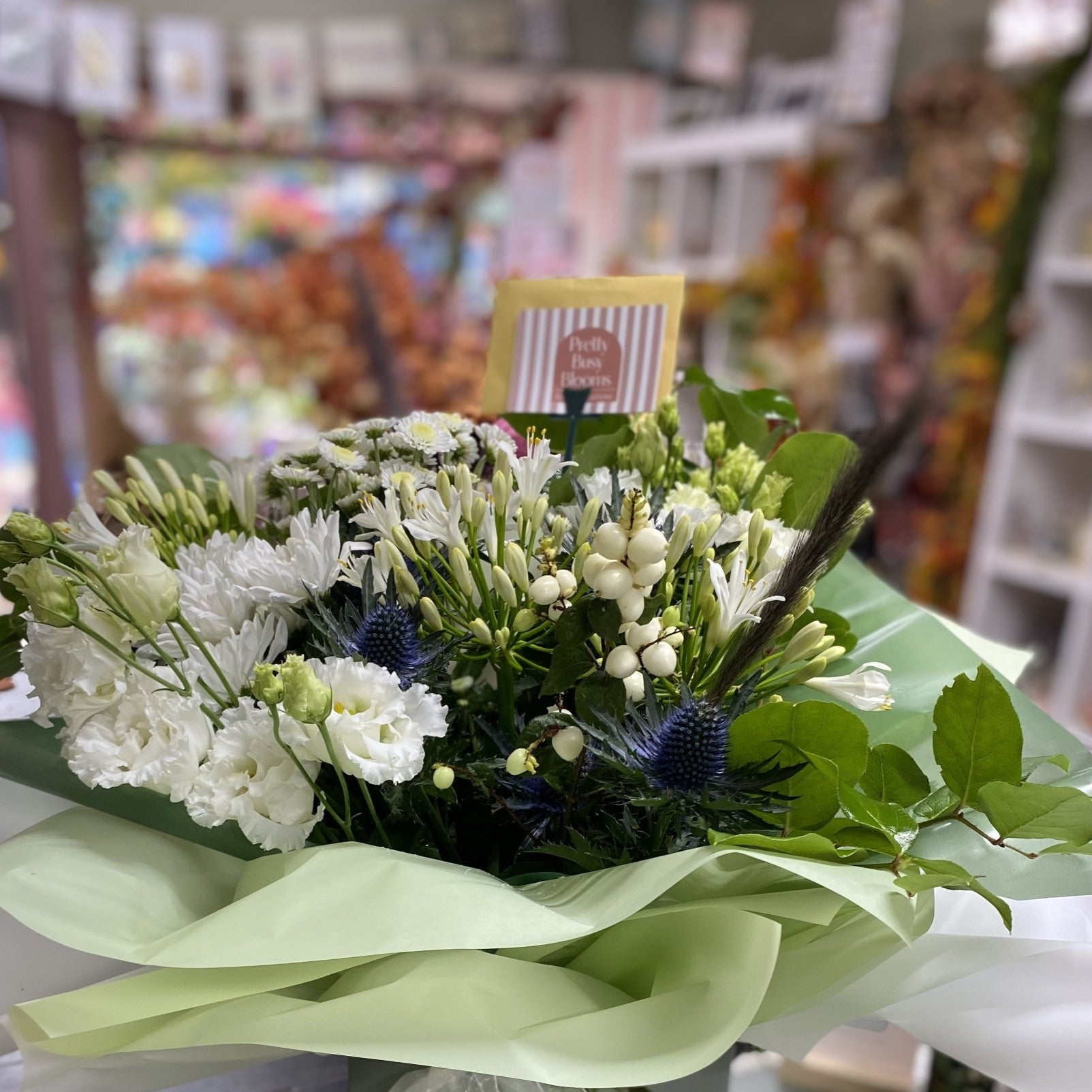 Bouquet of flowers with green ribbons on a table in a store setting